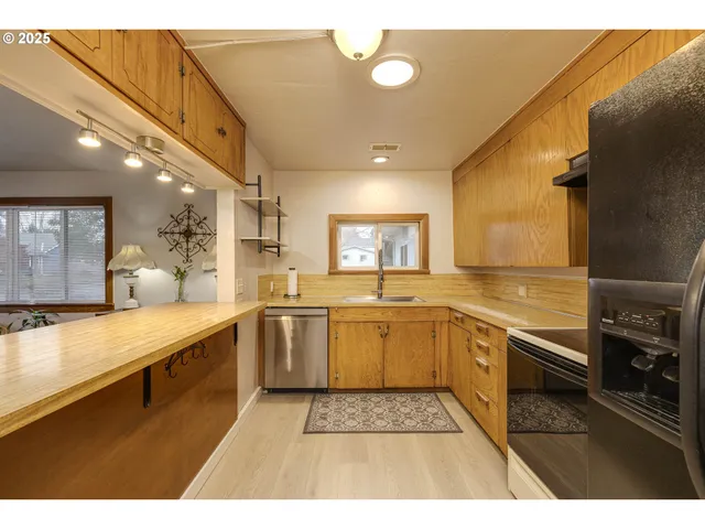 a large kitchen with stainless steel appliances granite countertop a sink and cabinets