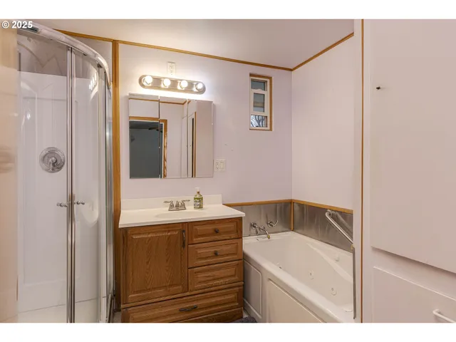 a bathroom with a tub a sink and mirror