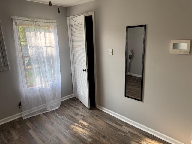 320 Rabbit Ranch Road Henderson, TN 38340 - Photo 12 of 29 Wood-finish flooring with white baseboards, window with white trim, and louvered bifold door