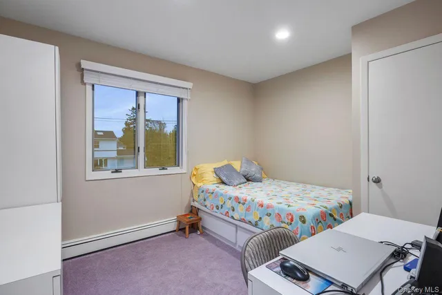 a bedroom with a bed and large window