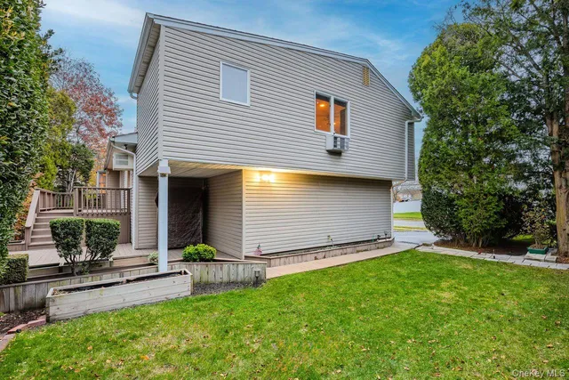 a view of a backyard with plants and a large tree