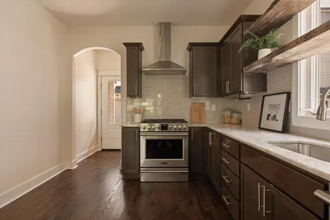 a kitchen with stainless steel appliances a sink dishwasher a refrigerator and cabinets with wooden floor