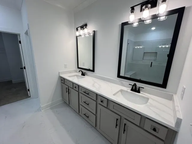 a bathroom with double vanity sink and a mirror
