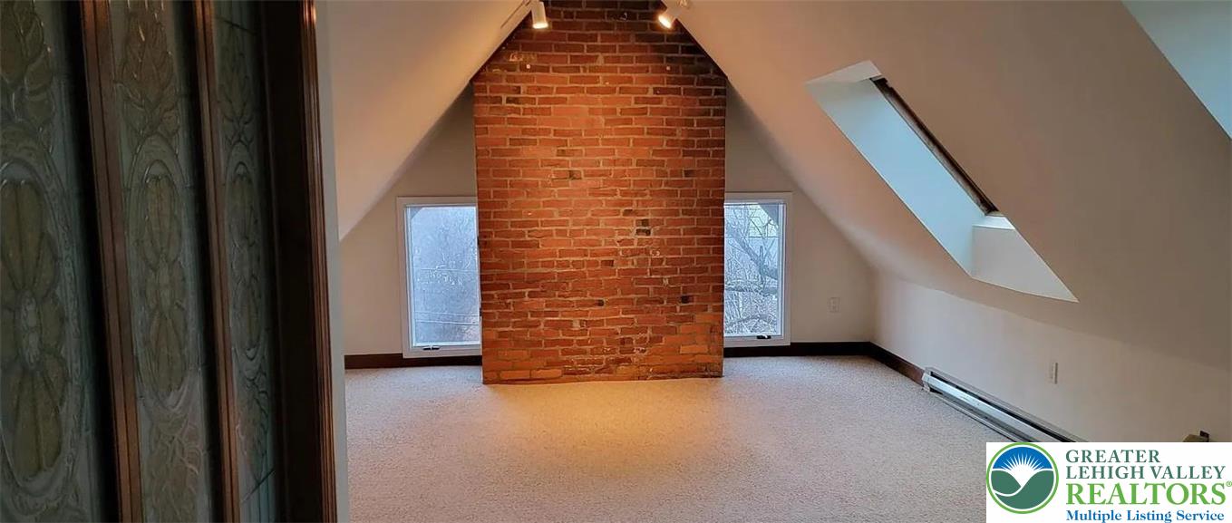 444 West 3rd Street, Unit 9 Bethlehem, PA 18015 - Photo 12 of 16 An inviting attic retreat with a prominent brick accent wall and cozy skylights.