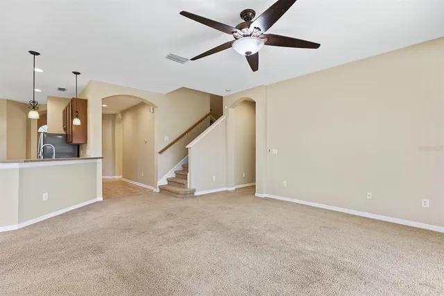 an empty room with ceiling fan and entryway