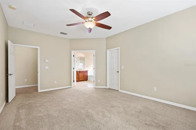 an empty room with closet and a ceiling fan