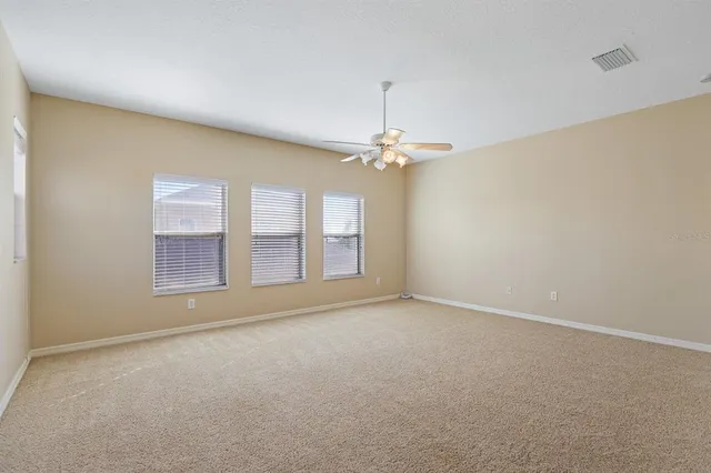 a view of an empty room with a chandelier fan