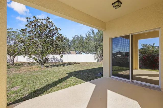 a view of a house with backyard and tree