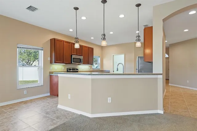 a kitchen with stainless steel appliances granite countertop a refrigerator a oven a sink and a microwave