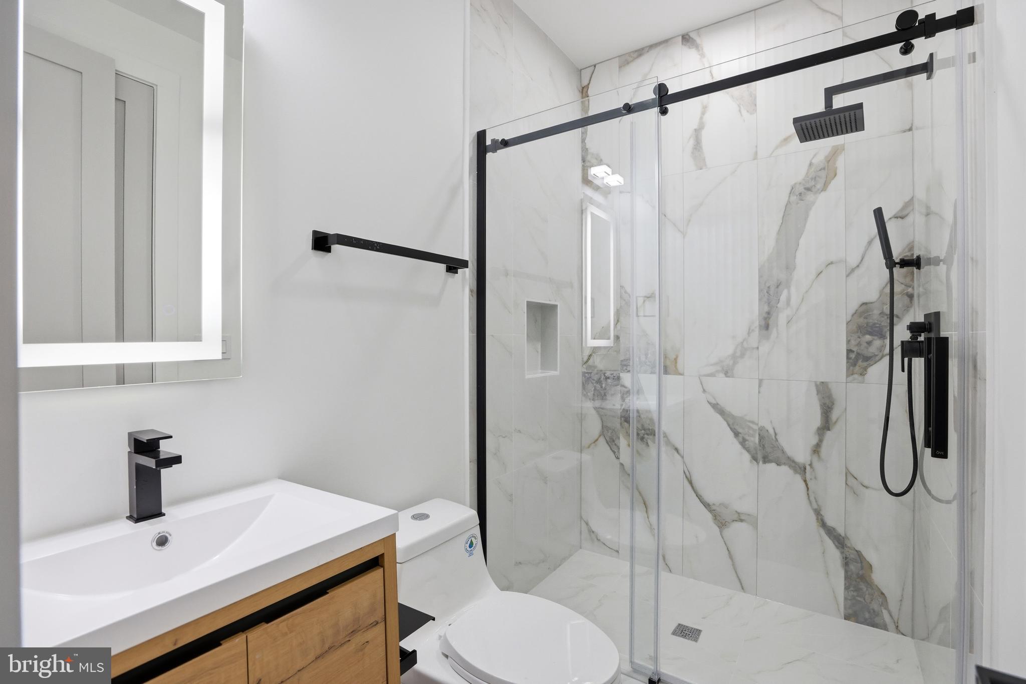 1140 Oates Street Northeast, Unit 101 Washington, DC 20002 - Photo 23 of 31 a bathroom with a shower toilet and sink