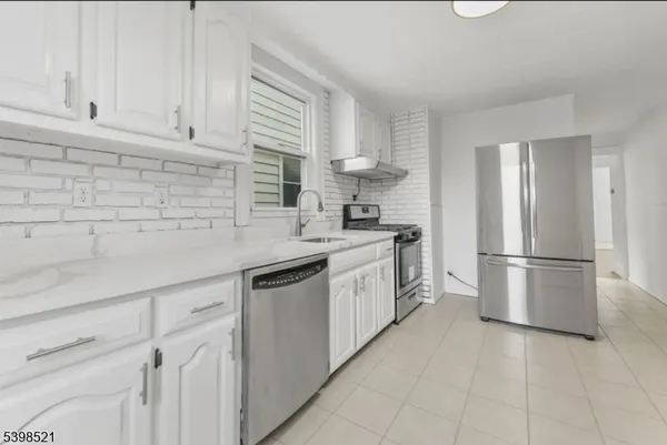 a kitchen with white cabinets and white appliances