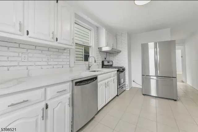 a kitchen with white cabinets and white appliances