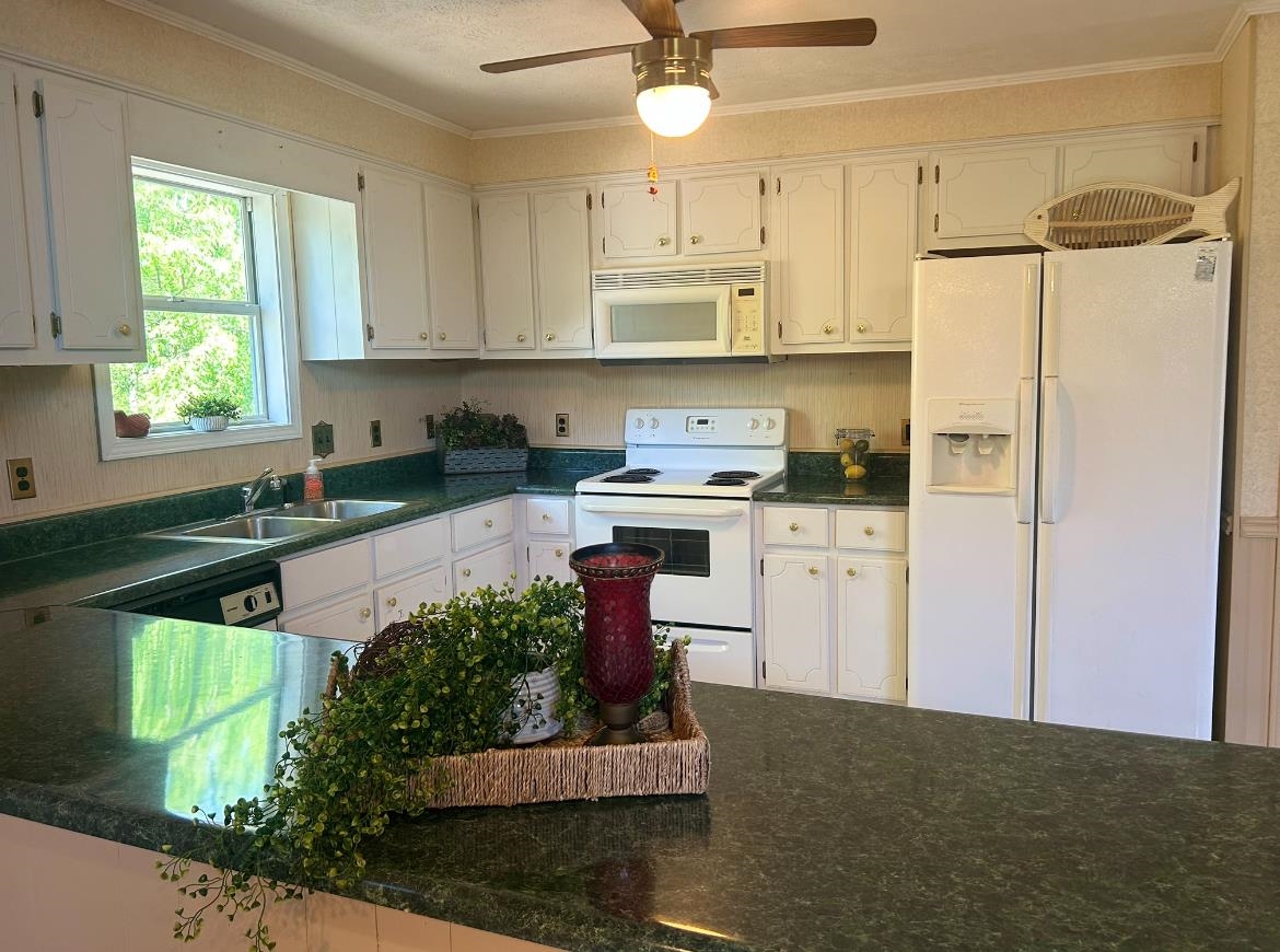 720 Riverside Lane Crump, TN 38327 - Photo 10 of 39 a kitchen with stainless steel appliances granite countertop a refrigerator a sink dishwasher a stove a dining table and chairs with wooden floor