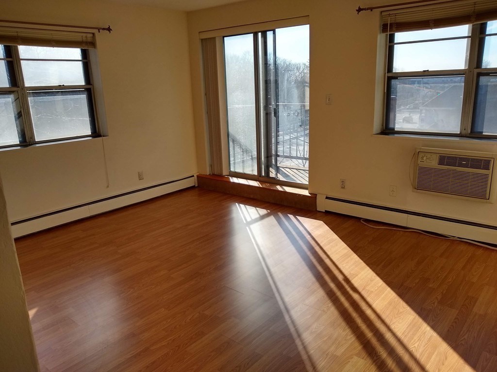4925 Washington Street, Unit 406 Boston, MA 02132 - Photo 3 of 11 a view of a room with wooden floor and windows