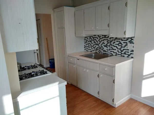 a kitchen with sink a stove and cabinets