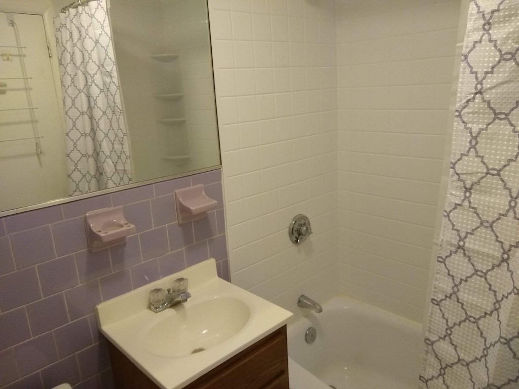 4925 Washington Street, Unit 406 Boston, MA 02132 - Photo 8 of 11 a bathroom with a sink and a bathtub