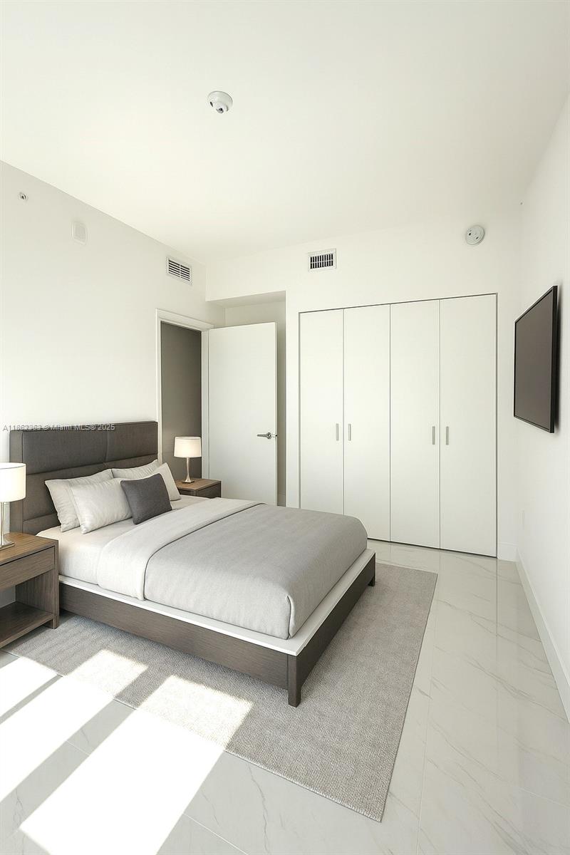 700 Northeast 24th Street, Unit 3701 Miami, FL 33137 - Photo 12 of 53 a spacious bedroom with a bed and a flat screen tv