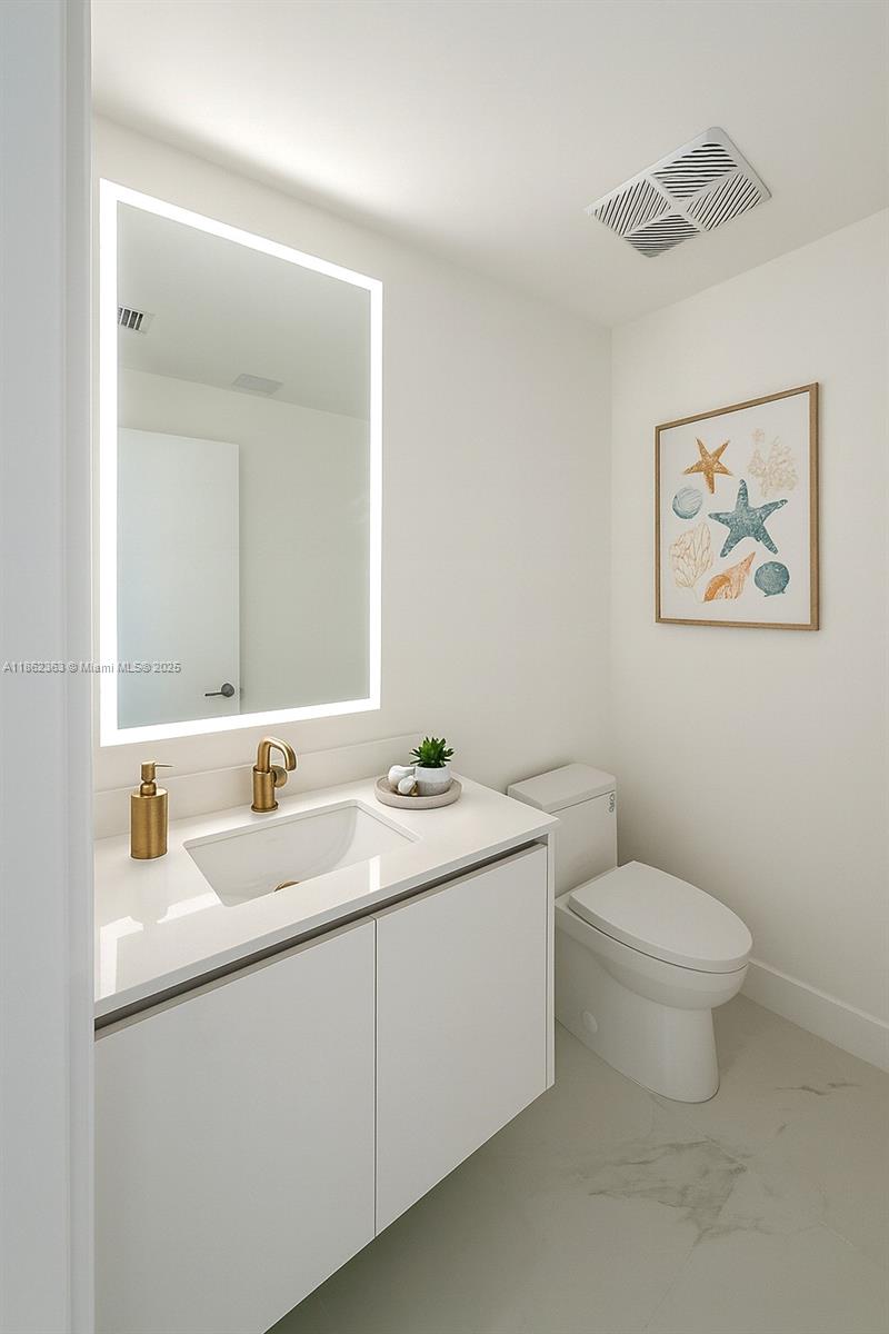 700 Northeast 24th Street, Unit 3701 Miami, FL 33137 - Photo 17 of 53 a bathroom with a toilet sink and mirror
