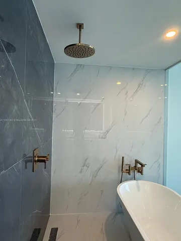 a bathroom with a bathtub a sink a toilet and shower