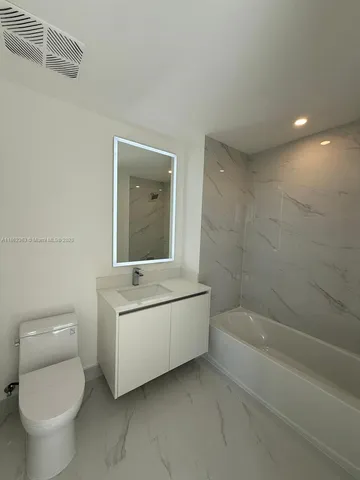 a bathroom with a sink toilet and mirror