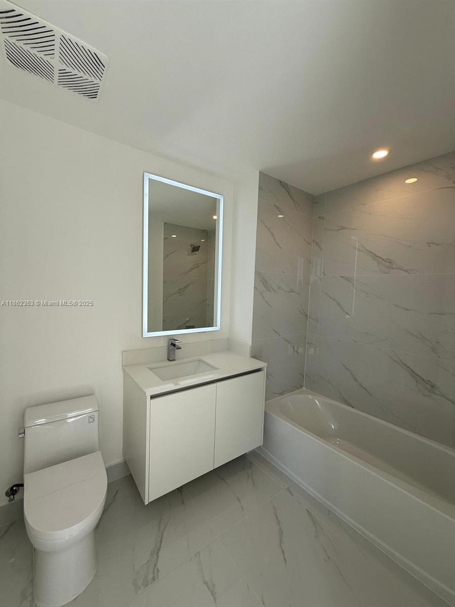 700 Northeast 24th Street, Unit 3701 Miami, FL 33137 - Photo 32 of 53 a bathroom with a sink a toilet and bathtub