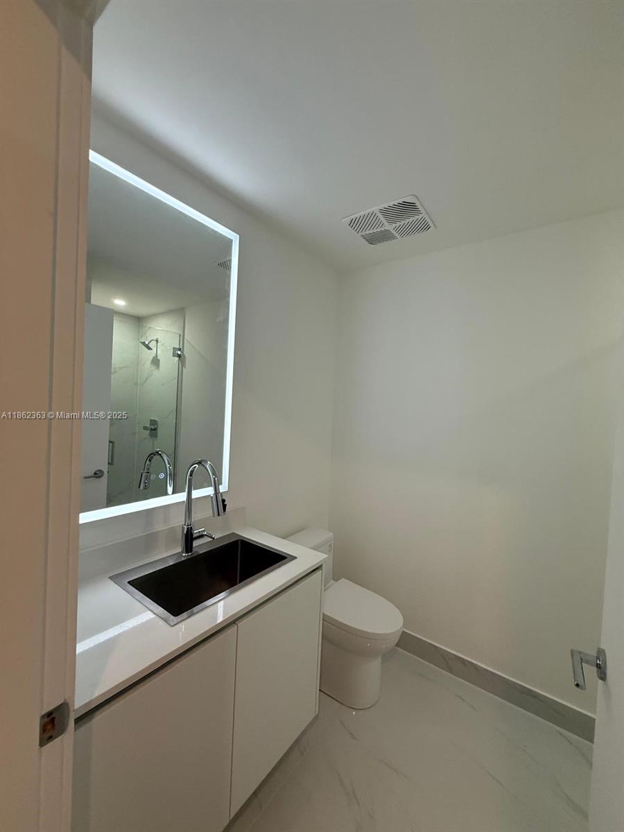 700 Northeast 24th Street, Unit 3701 Miami, FL 33137 - Photo 33 of 53 a bathroom with a sink toilet and mirror