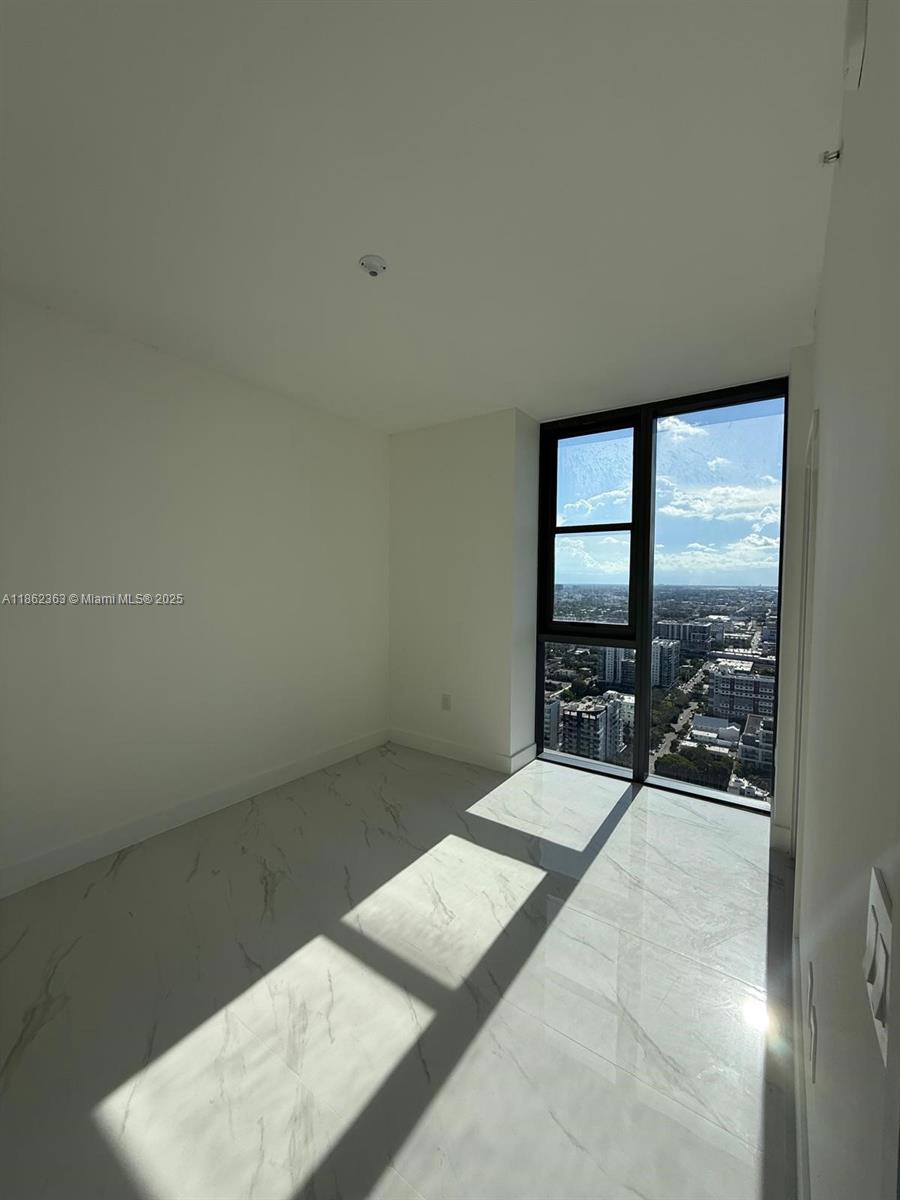 700 Northeast 24th Street, Unit 3701 Miami, FL 33137 - Photo 34 of 53 a bedroom with a bed and large window