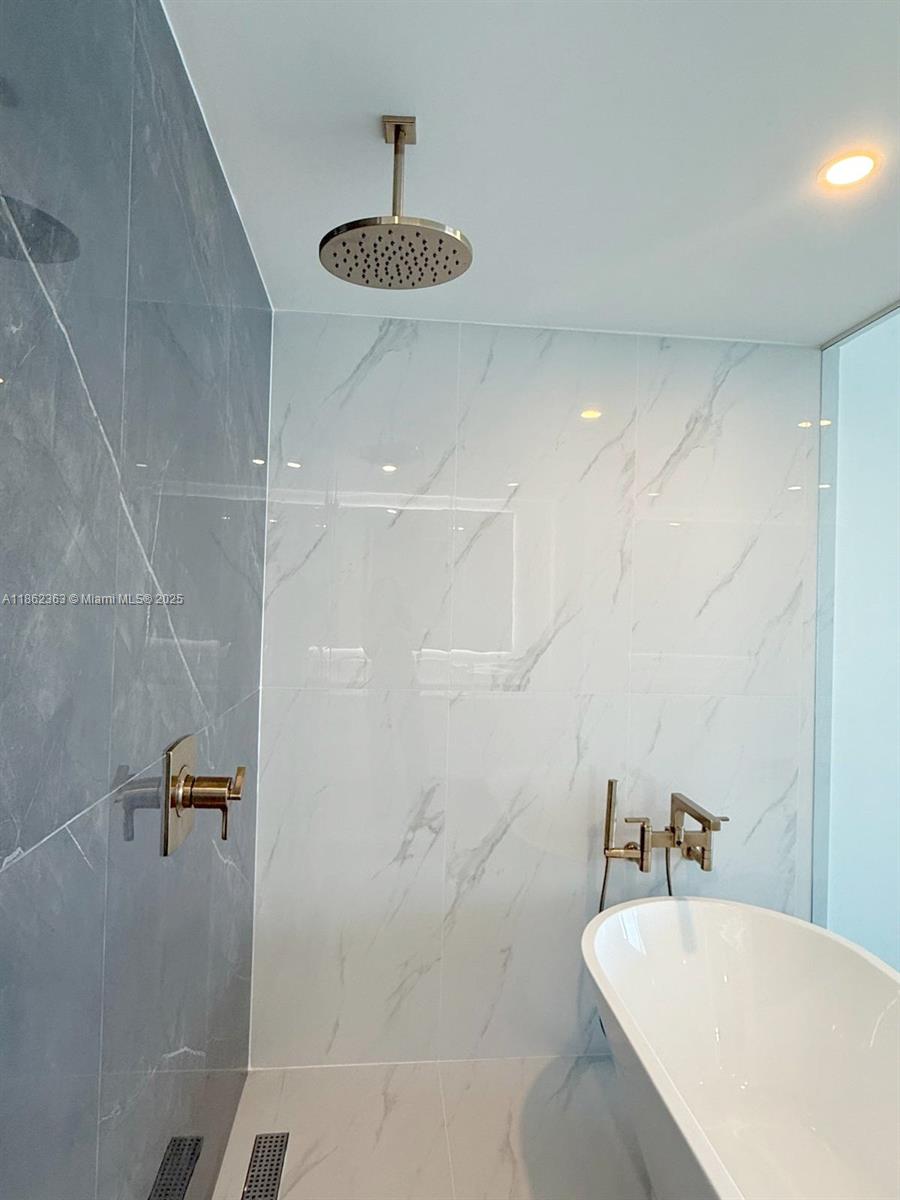 700 Northeast 24th Street, Unit 3701 Miami, FL 33137 - Photo 37 of 53 a bathroom with a bathtub a sink a toilet and shower