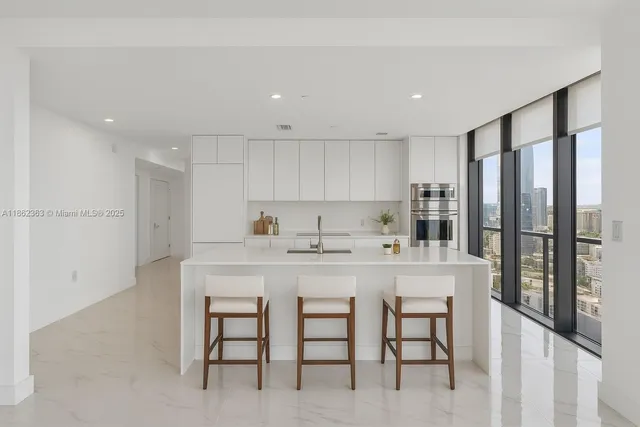 a kitchen with a sink and chairs