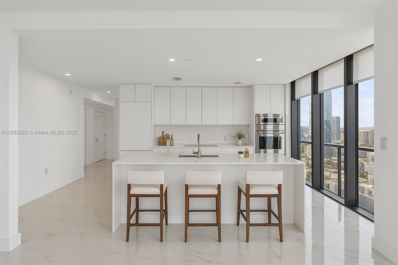 700 Northeast 24th Street, Unit 3701 Miami, FL 33137 - Photo 9 of 53 a kitchen with a sink and chairs