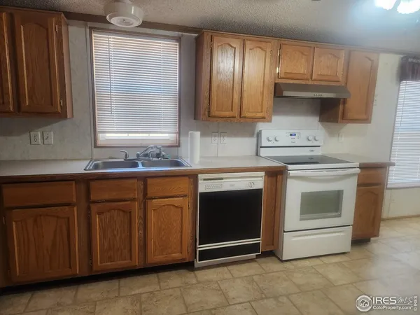 a kitchen with granite countertop wooden cabinets stainless steel appliances and a sink