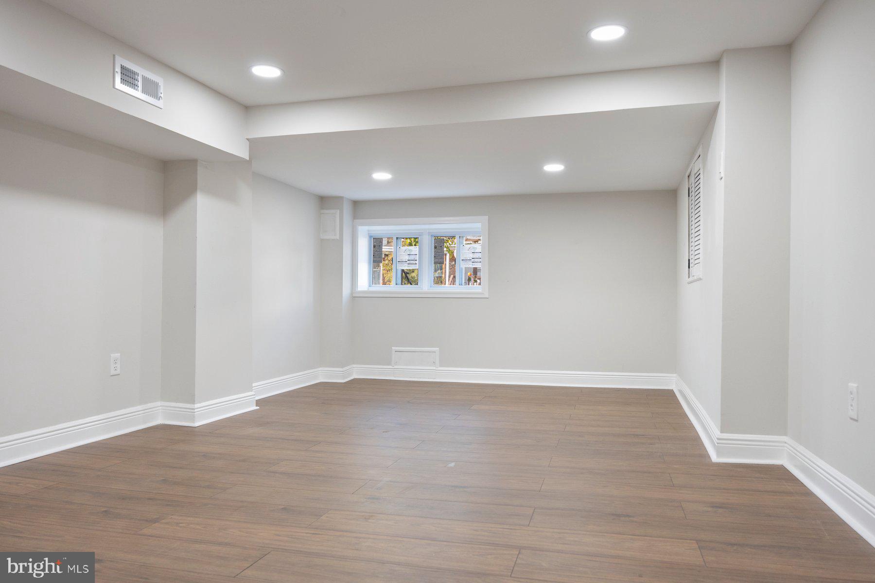 117 Collins Avenue Baltimore, MD 21229 - Photo 24 of 27 a view of an empty room with wooden floor and a window