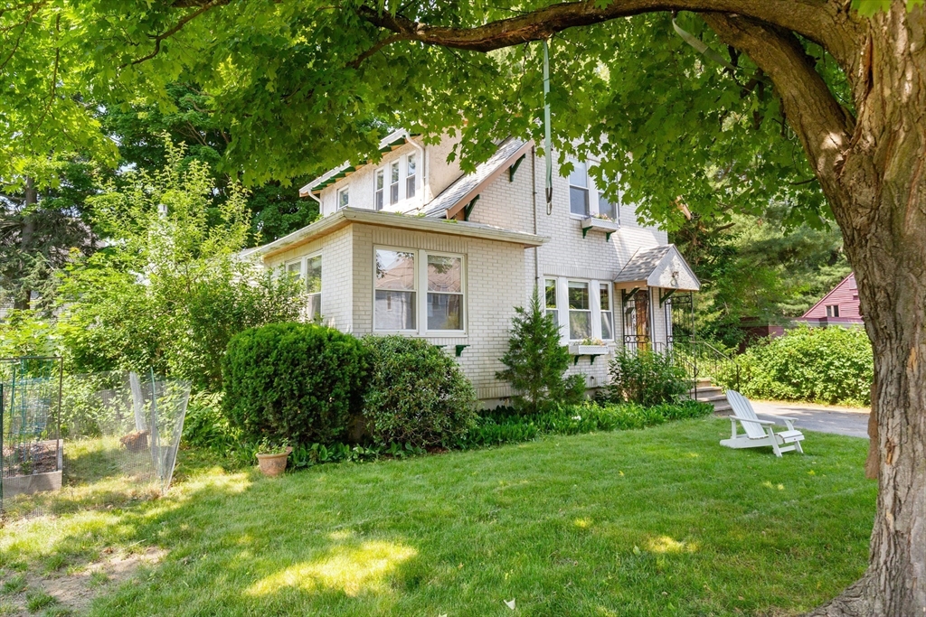 a view of a house with a yard and potted plants