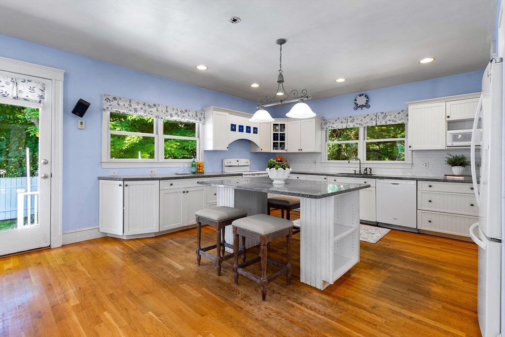 102 Gleason Road Lexington, MA 02420 - Photo 16 of 37 a kitchen with kitchen island granite countertop a stove a sink a island and chairs in it