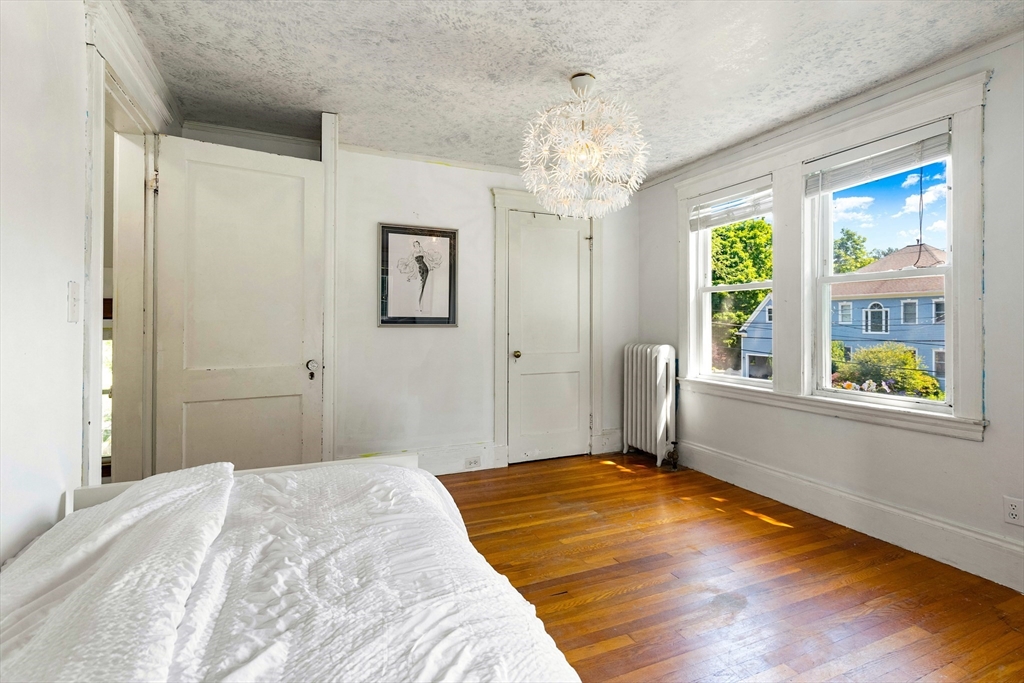 102 Gleason Road Lexington, MA 02420 - Photo 25 of 37 a bedroom with a large bed and a chandelier