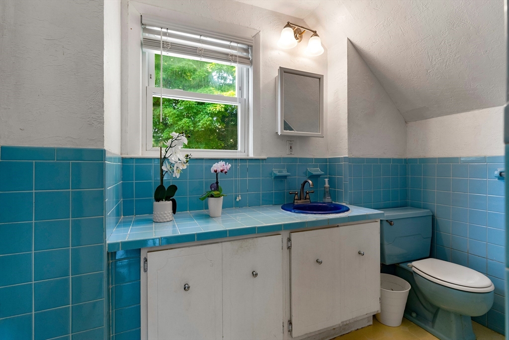 102 Gleason Road Lexington, MA 02420 - Photo 26 of 37 a bathroom with a granite countertop sink a toilet and a window
