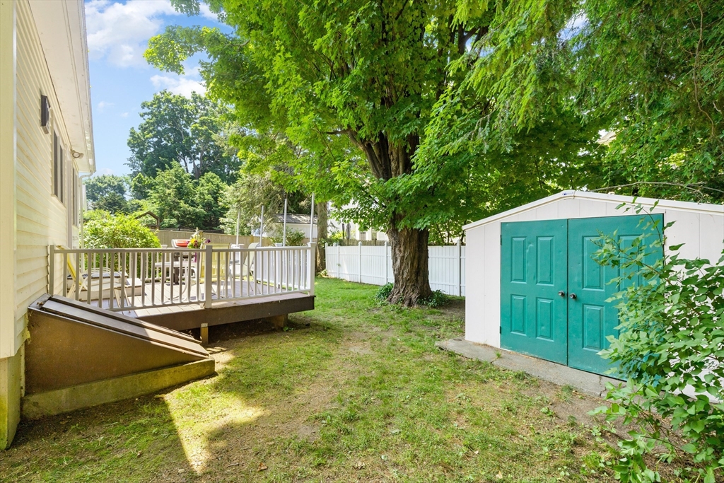 102 Gleason Road Lexington, MA 02420 - Photo 35 of 37 a view of a house with a wooden deck and a small yard