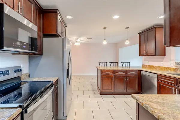a kitchen with stainless steel appliances granite countertop a sink and a stove