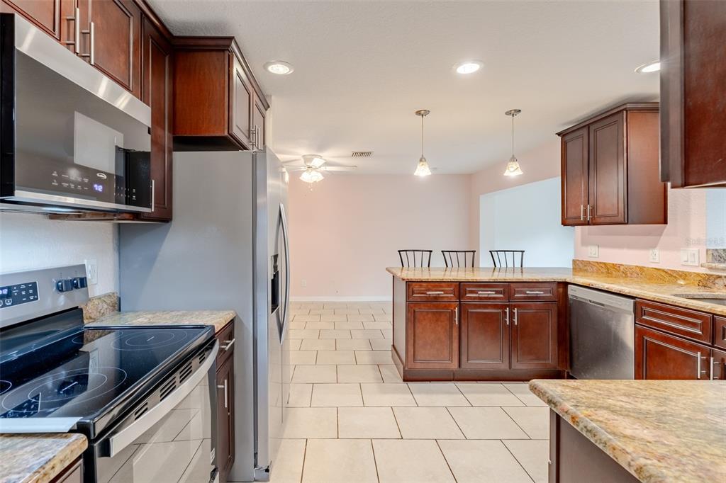 8918 134th Street North Seminole, FL 33776 - Photo 15 of 37 a kitchen with stainless steel appliances granite countertop a sink and a stove