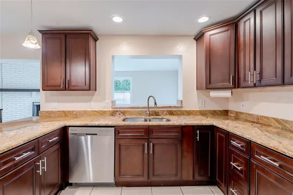 a kitchen with stainless steel appliances granite countertop wooden cabinets a sink and dishwasher