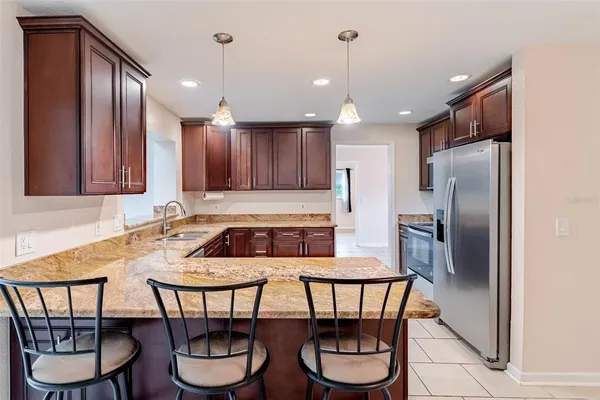 a kitchen with a dining table chairs and refrigerator