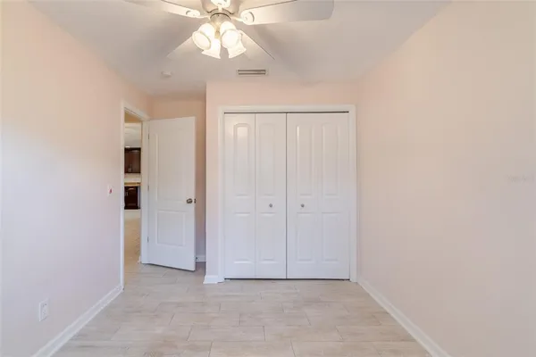 an empty room with a ceiling fan and a window