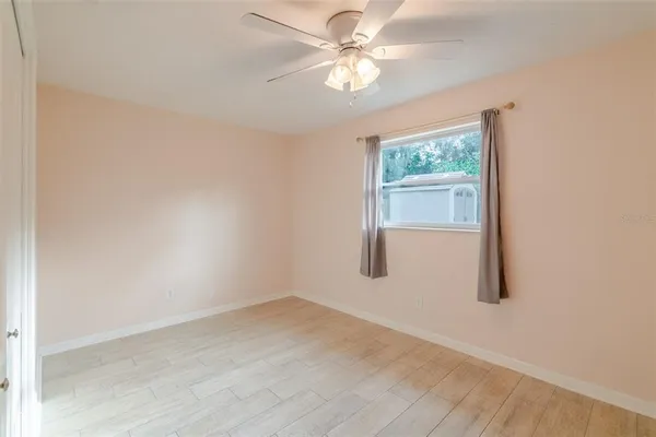 an empty room with a window and a fan