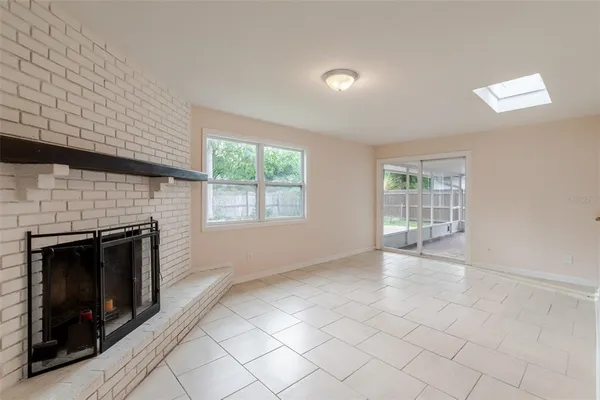 an empty room with windows and fireplace