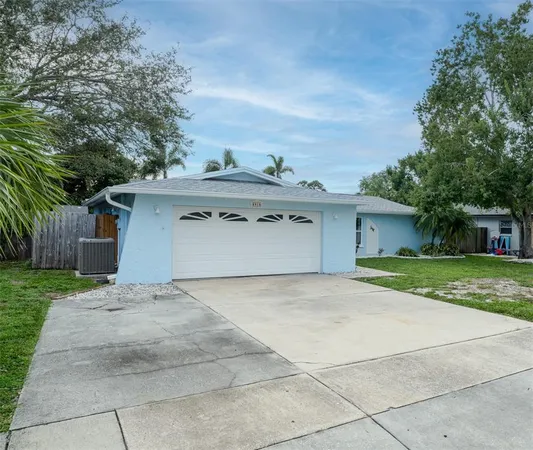 a view of a house with a yard and large tree