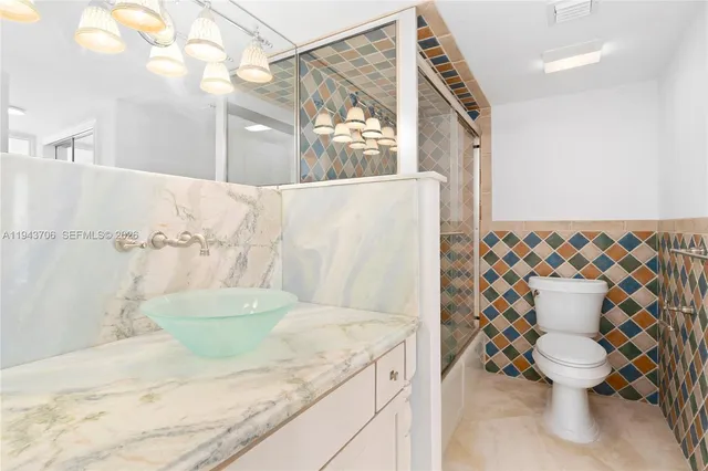 a bathroom with a granite countertop sink a toilet and a mirror