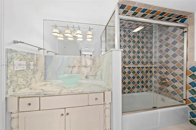 a bathroom with a granite countertop sink and a shower