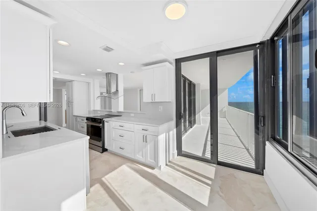 a kitchen with stainless steel appliances granite countertop a stove a sink and a refrigerator