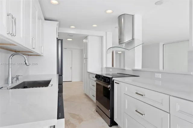 a kitchen with granite countertop a sink stove and refrigerator