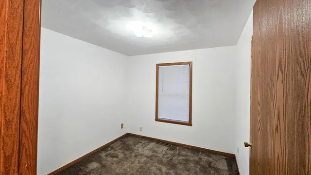 an empty room with wooden floor and entrance